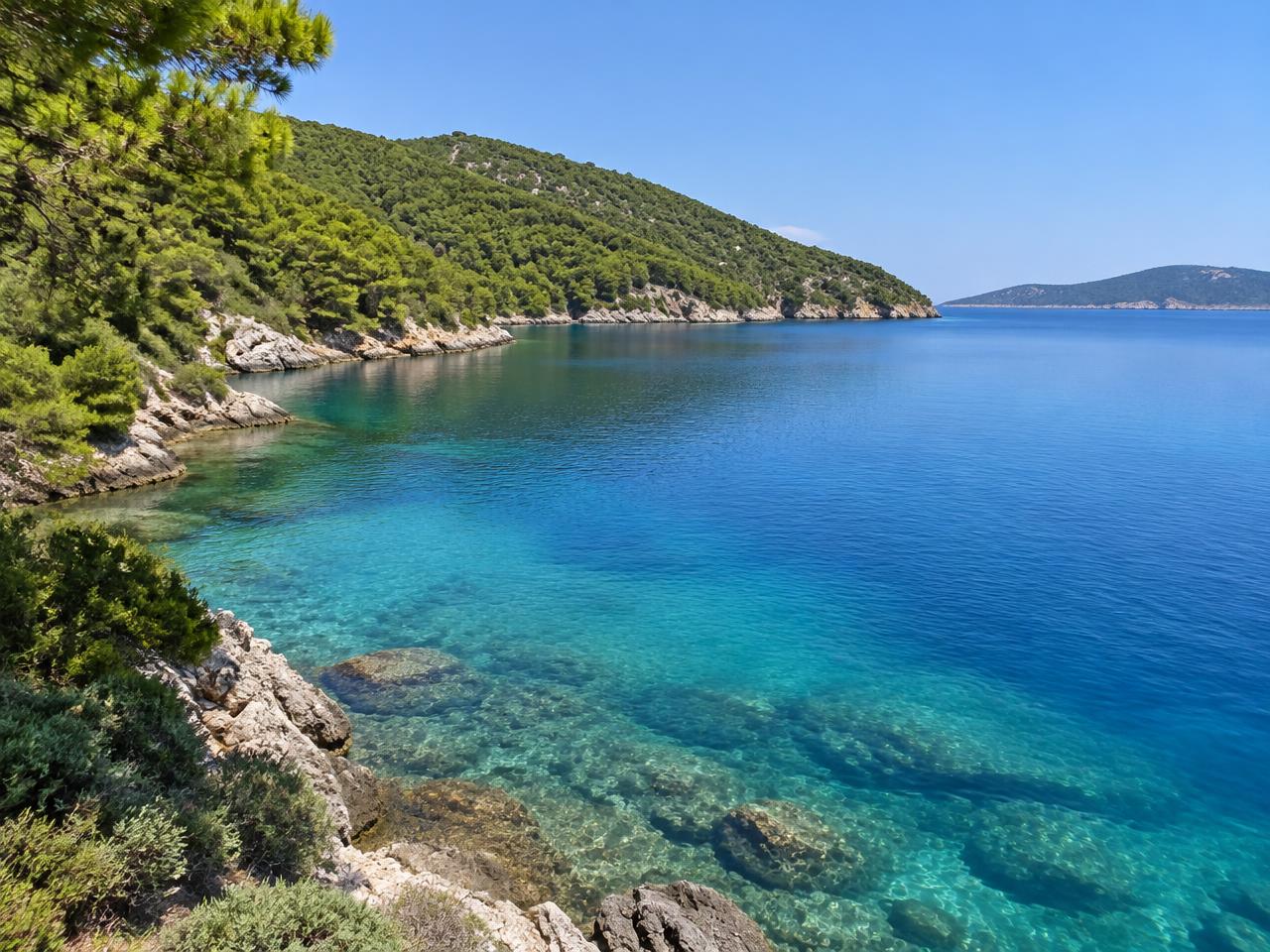 Ruhige Bucht mit klarem Wasser und bewaldeten Hängen auf Alonissos